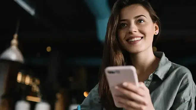 woman smiling holding a phone